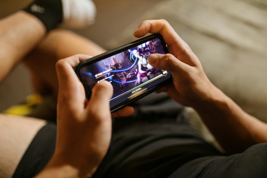 A person playing a mobile video game on a smartphone, focusing on gaming and technology lifestyle.