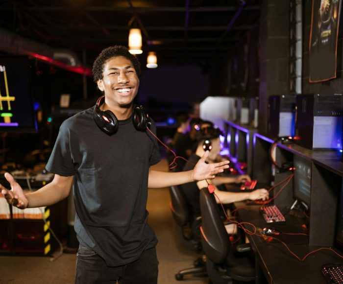 Smiling gamer enjoying time in a modern gaming studio with advanced technology.