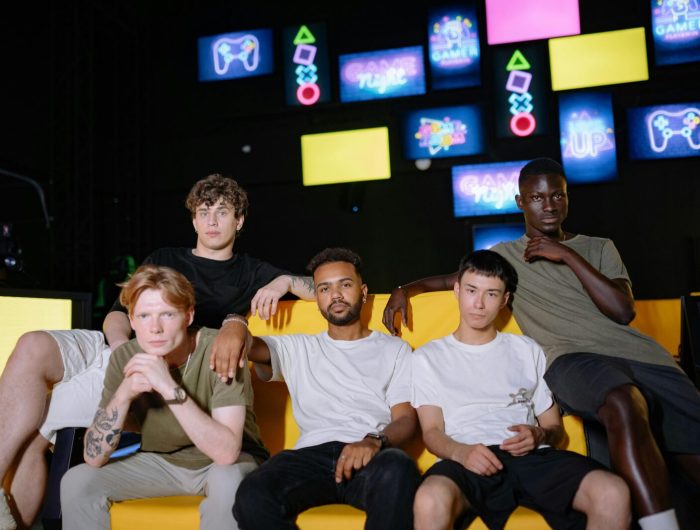 A diverse group of young men sitting together at a gaming event, showcasing friendship and togetherness.