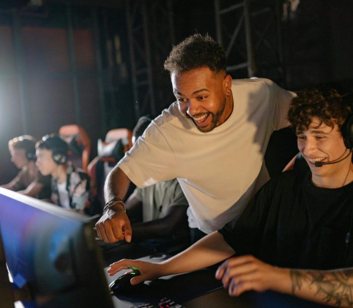 Gamers in a high-energy tournament setting enjoy competitive play with enthusiasm and teamwork.